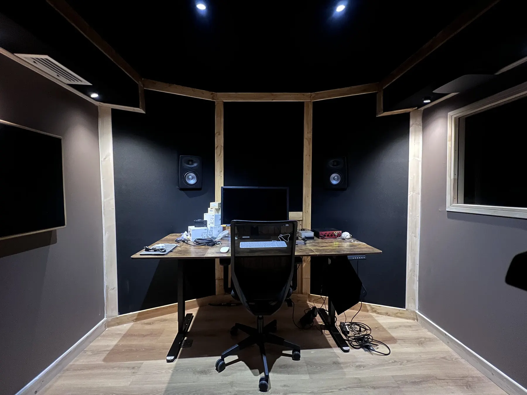 Control room livrée vue depuis l’entrée : parois non parallèles, panneaux et poutres bois.